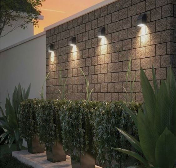14 Side Return Garden Ideas: Use the Narrow Side of House! 8 four spotlights along a garden wall, pointing dowards at the bottom plants below, making them look very dramatic